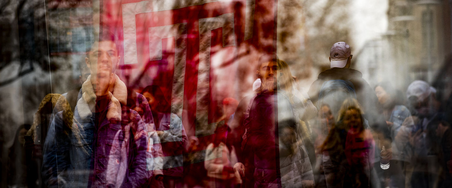 An abstract photo of the cherry Temple T flag overlay with students in the background